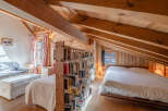 Discover the charm of this cozy cabin retreat, featuring a unique bookshelf that divides the living space.