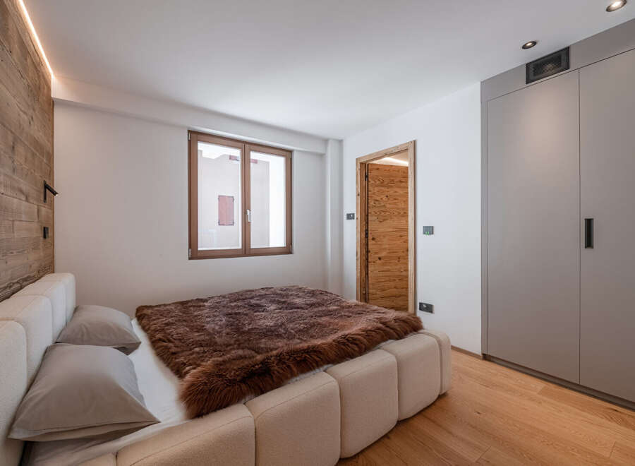 This cozy bedroom features a luxurious bed with a plush, brown fur throw, creating a warm and inviting atmosphere.
