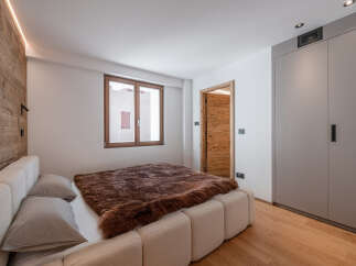 This cozy bedroom features a luxurious bed with a plush, brown fur throw, creating a warm and inviting atmosphere.