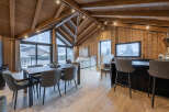 Experience luxury living in this stunning chalet, featuring a spacious open-plan design with a dining area and a modern kitchen.