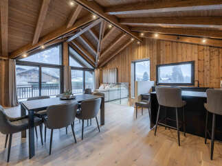 Experience luxury living in this stunning chalet, featuring a spacious open-plan design with a dining area and a modern kitchen.
