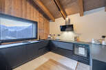 This stunning kitchen boasts a modern design with sleek, dark cabinetry and a beautiful view of the mountains.