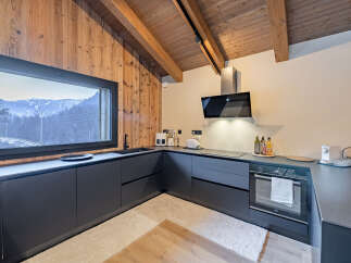 This stunning kitchen boasts a modern design with sleek, dark cabinetry and a beautiful view of the mountains.