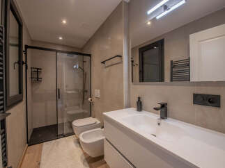 Step into a modern bathroom oasis! This stunning space features a sleek glass shower enclosure, a contemporary vanity with a stylish faucet, and elegant tile work.