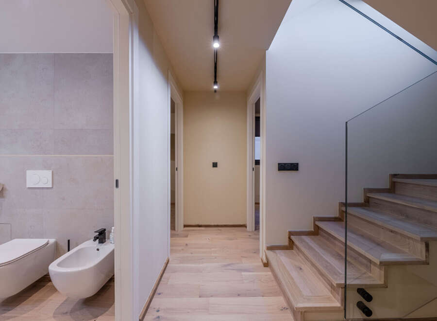This modern home features a stylish hallway with hardwood floors and recessed lighting.
