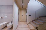This modern home features a stylish hallway with hardwood floors and recessed lighting.