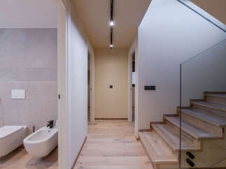 This modern home features a stylish hallway with hardwood floors and recessed lighting.