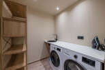 This modern laundry room boasts a sleek design with a washing machine and a sink, perfect for efficient home management.