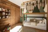 This charming bedroom features a unique bunk bed design with a cozy seating area below, perfect for relaxation.