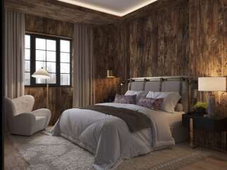 Experience rustic elegance in this stunning bedroom featuring rich wood paneling and a cozy ambiance.