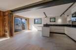 This stunning property boasts a modern kitchen with sleek white cabinetry and a contrasting black countertop.