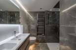 Step into luxury with this stunning bathroom featuring sleek marble tiles and modern fixtures.