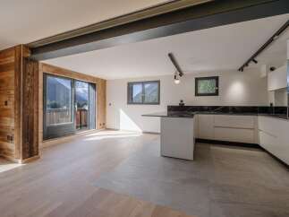This stunning property boasts a modern kitchen with sleek white cabinetry and a contrasting black countertop.