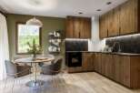 This stunning kitchen boasts a modern design with sleek wooden cabinetry and a contrasting black backsplash.
