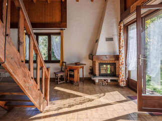 Step into this inviting living space, featuring a charming wooden staircase and a cozy fireplace, perfect for creating a warm and welcoming atmosphere.