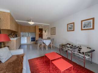 Discover this stylish apartment featuring a modern kitchen and a cozy living area.