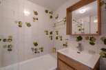 This charming bathroom features a unique design with leaf-patterned tiles, creating a fresh and inviting atmosphere.