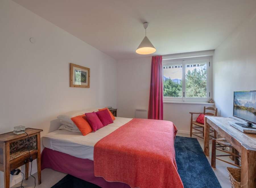 This cozy bedroom offers a serene retreat with its inviting ambiance and natural light.