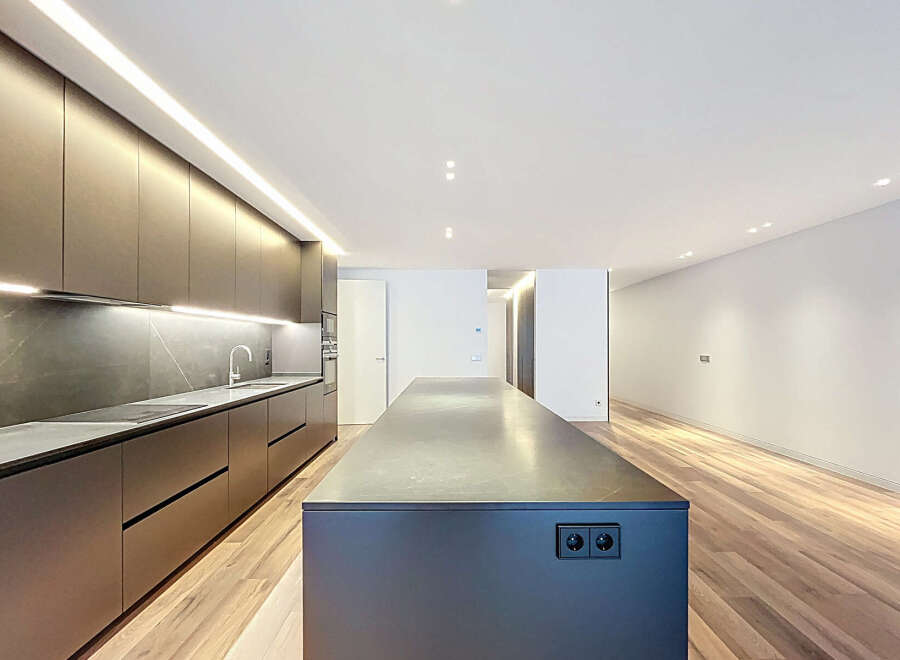 This modern kitchen boasts sleek, dark cabinetry and a spacious island, perfect for culinary endeavors and entertaining.