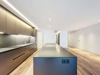 This modern kitchen boasts sleek, dark cabinetry and a spacious island, perfect for culinary endeavors and entertaining.