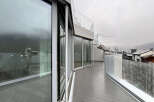 Experience breathtaking views from this modern property featuring expansive glass windows and a spacious balcony.