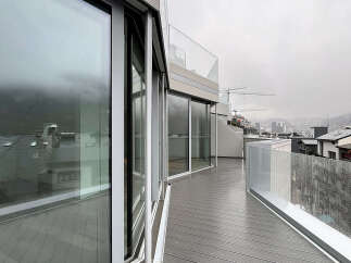 Experience breathtaking views from this modern property featuring expansive glass windows and a spacious balcony.