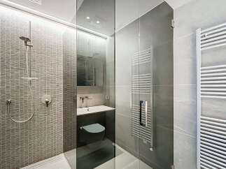 Step into a modern bathroom oasis! This stunning space features a sleek glass shower enclosure, a stylish heated towel rack, and elegant tile work.