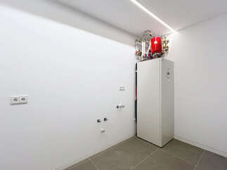 Modern utility room showcasing a sleek, white heat pump system.