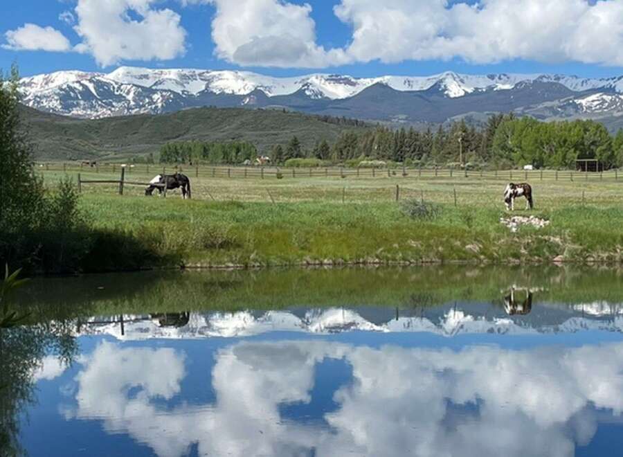 Experience the tranquility of this stunning property, featuring breathtaking mountain views and a serene pond.