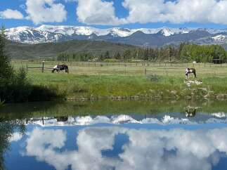 Experience the tranquility of this stunning property, featuring breathtaking mountain views and a serene pond.