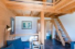 This stunning chalet boasts a spacious open-plan living area with a cozy sofa and a unique loft bedroom.