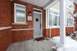 This charming property boasts a welcoming facade with a brick exterior and a well-maintained front porch.