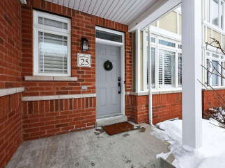 This charming property boasts a welcoming facade with a brick exterior and a well-maintained front porch.