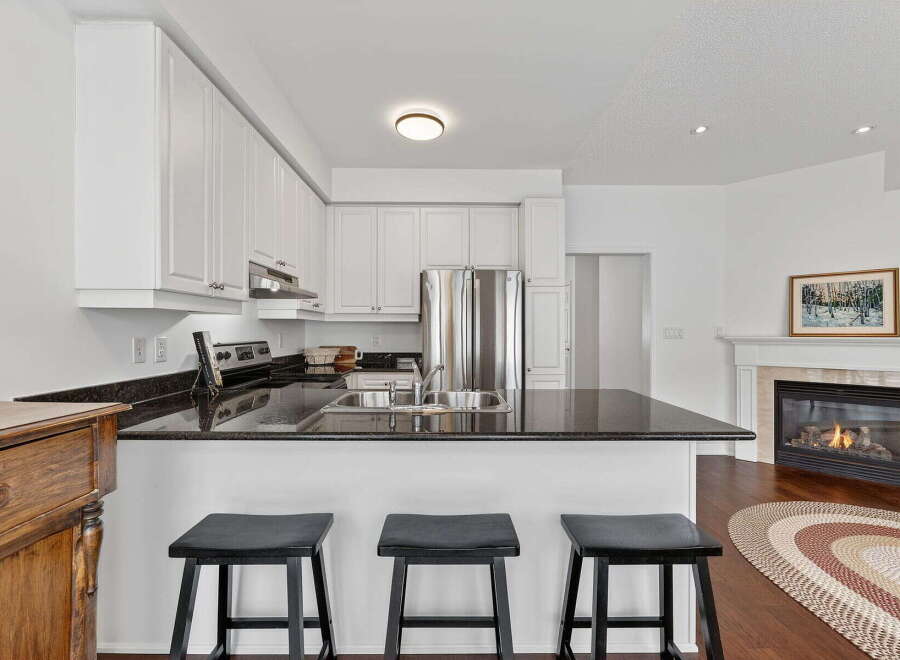 This stunning kitchen boasts sleek granite countertops, stainless steel appliances, and ample cabinet space, perfect for culinary enthusiasts.