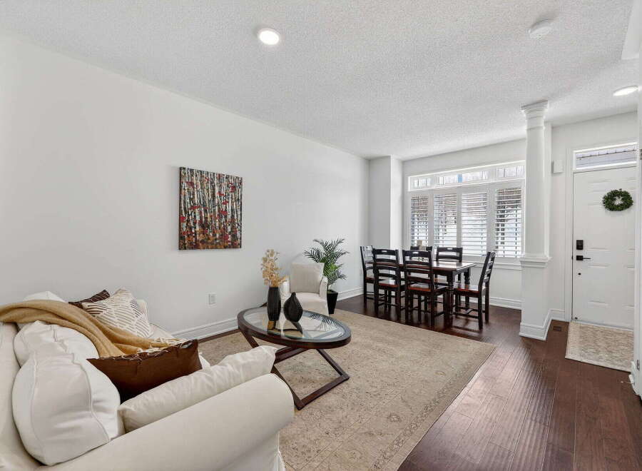 Step into this inviting living space, featuring a bright and airy ambiance with pristine white walls and elegant hardwood floors.