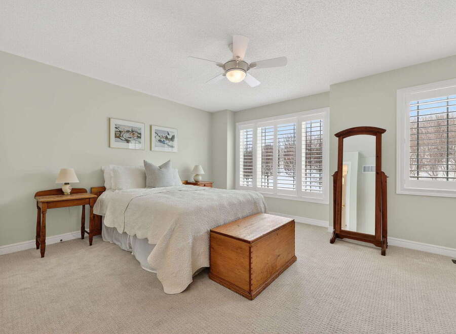 This inviting bedroom showcases a cozy ambiance with its neutral color palette and ample natural light.