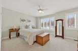 This inviting bedroom showcases a cozy ambiance with its neutral color palette and ample natural light.