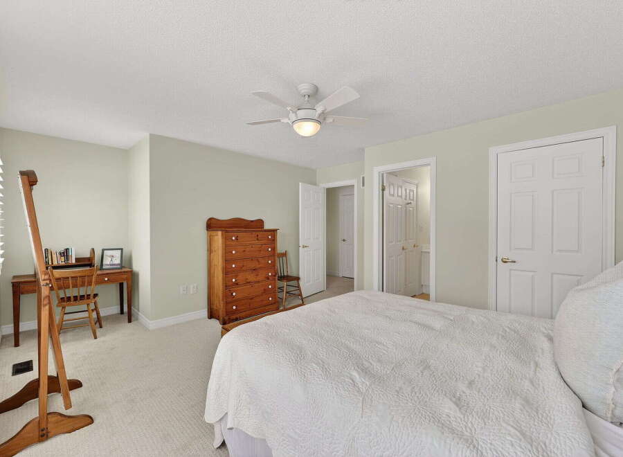 This inviting bedroom offers a serene retreat with its neutral color palette and ample natural light.