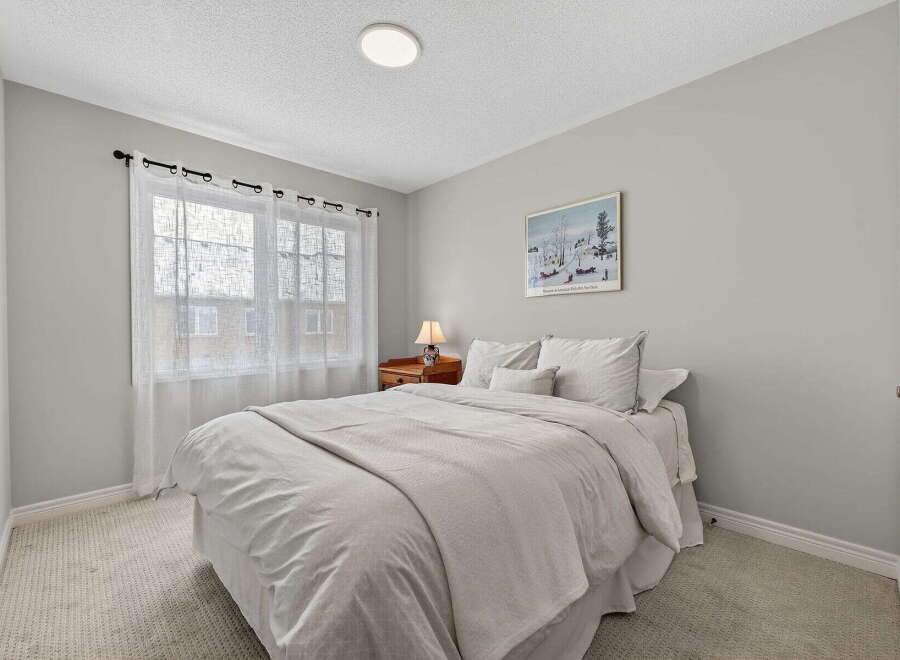Step into this cozy bedroom, featuring a comfortable bed and soft bedding.