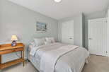 This cozy bedroom offers a serene retreat with its soft, neutral color palette and ample natural light.