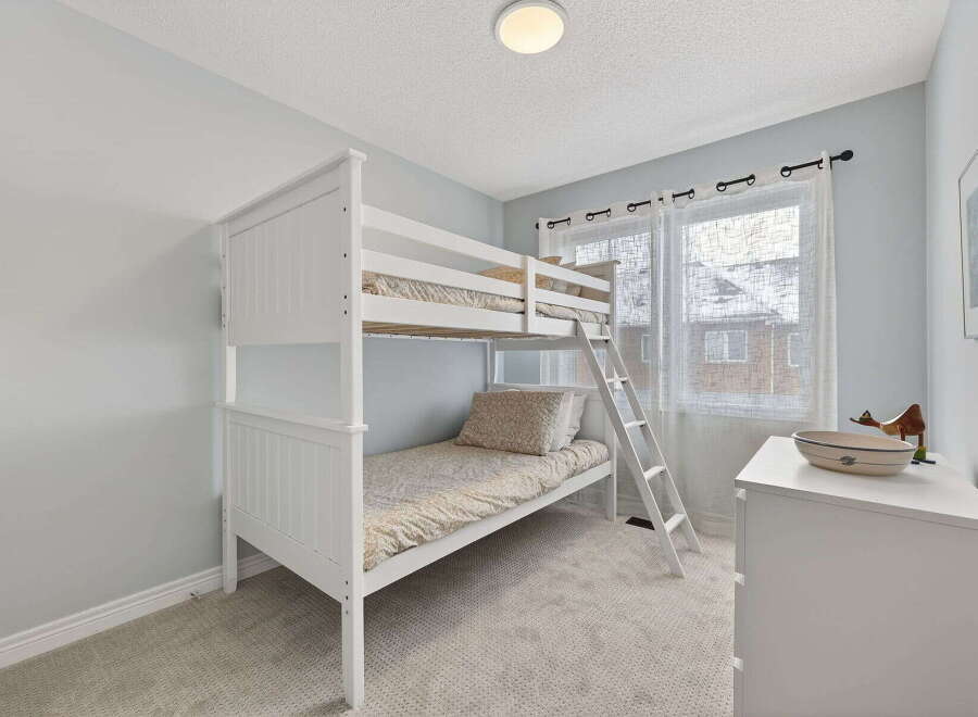 This charming bedroom features a stylish white bunk bed, perfect for maximizing space.