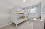 This charming bedroom features a stylish white bunk bed, perfect for maximizing space.