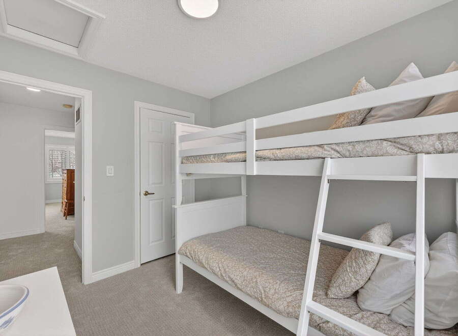This charming bedroom features a cozy bunk bed, perfect for kids or guests.