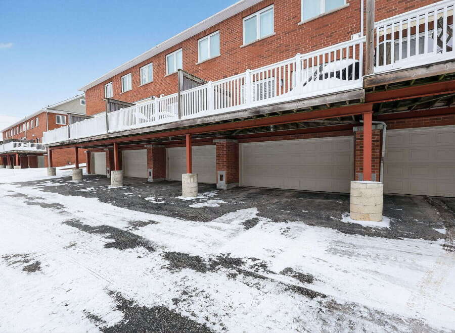 Discover this stunning property featuring a row of townhouses with attached garages, perfect for convenient parking and storage.