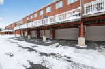 Discover this stunning property featuring a row of townhouses with attached garages, perfect for convenient parking and storage.