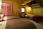 Cozy chalet bedroom with twin beds and a single bed, perfect for families or groups.