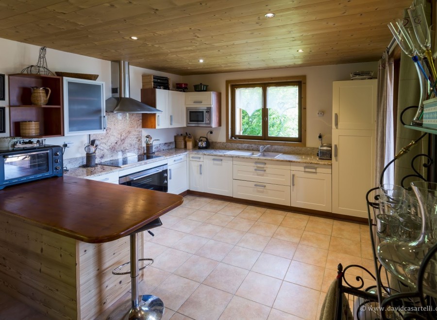 This charming kitchen boasts a rustic-chic design with wood accents and granite countertops.
