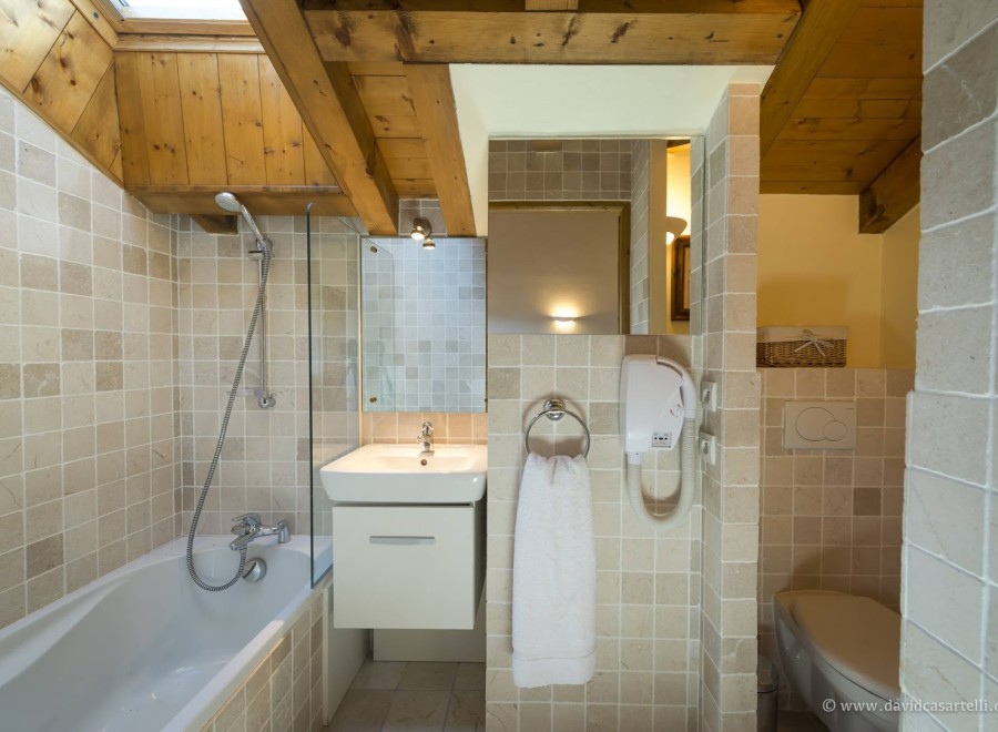 This charming bathroom boasts a relaxing bathtub, a separate shower, and a modern vanity with a sleek white cabinet.