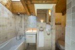 This charming bathroom boasts a relaxing bathtub, a separate shower, and a modern vanity with a sleek white cabinet.