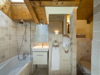 This charming bathroom boasts a relaxing bathtub, a separate shower, and a modern vanity with a sleek white cabinet.